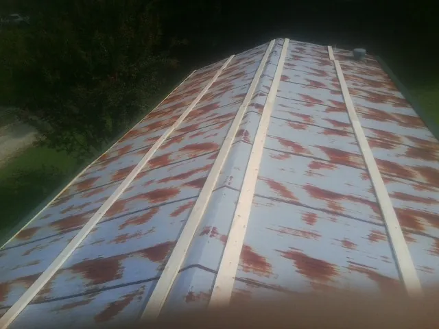Rusted metal roof panels with new wood purlins before replacement — Storm Damage Roof Repair in Gobles by Roofing Brothers